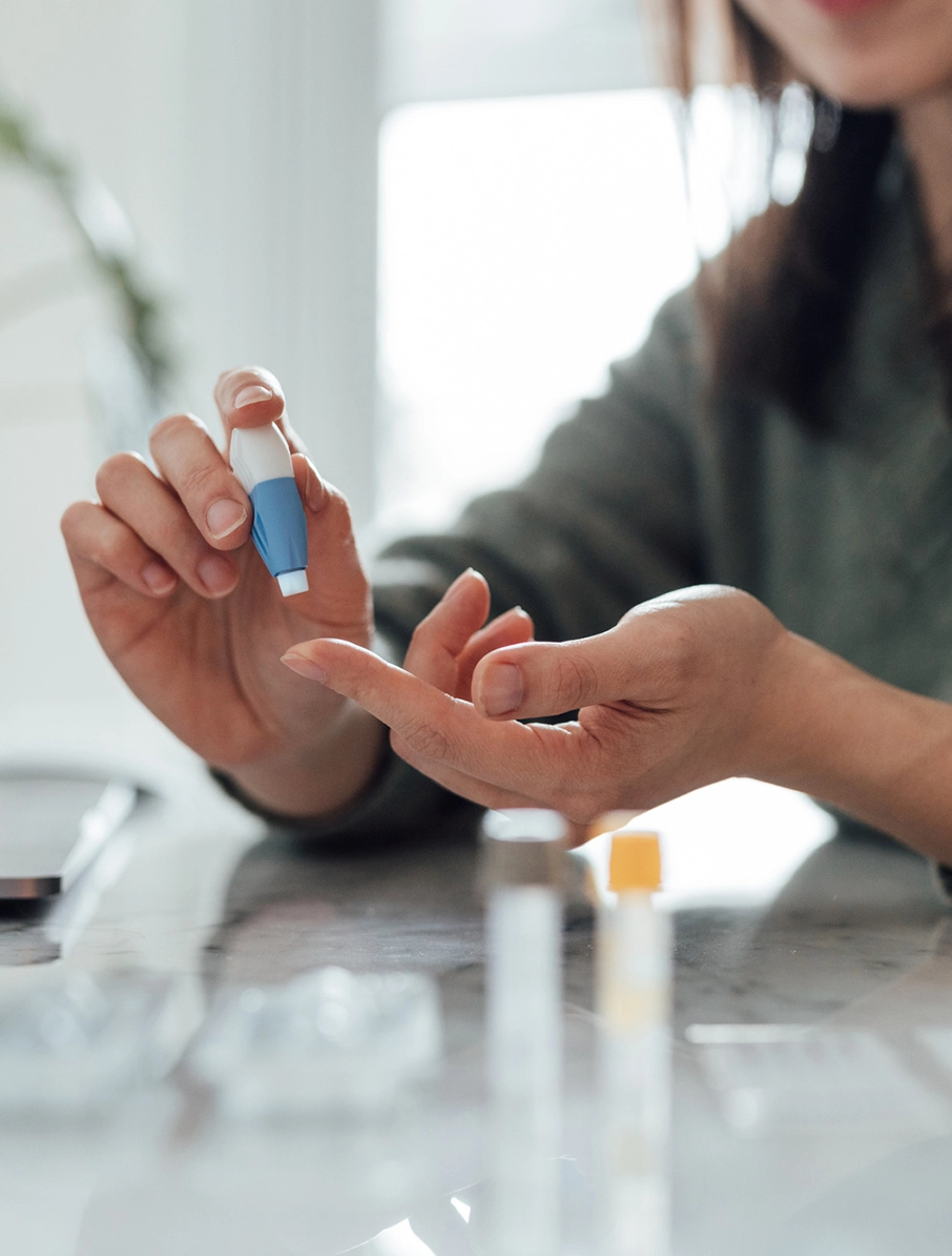 Person using a lancet to prick her own finger in an at-home blood test